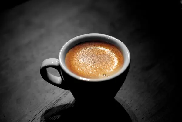 Espresso à la crema dorée dans une tasse sombre