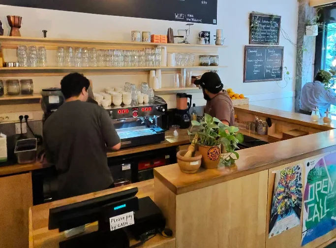 Intérieur de café avec tables en bois, fauteuils et plantes